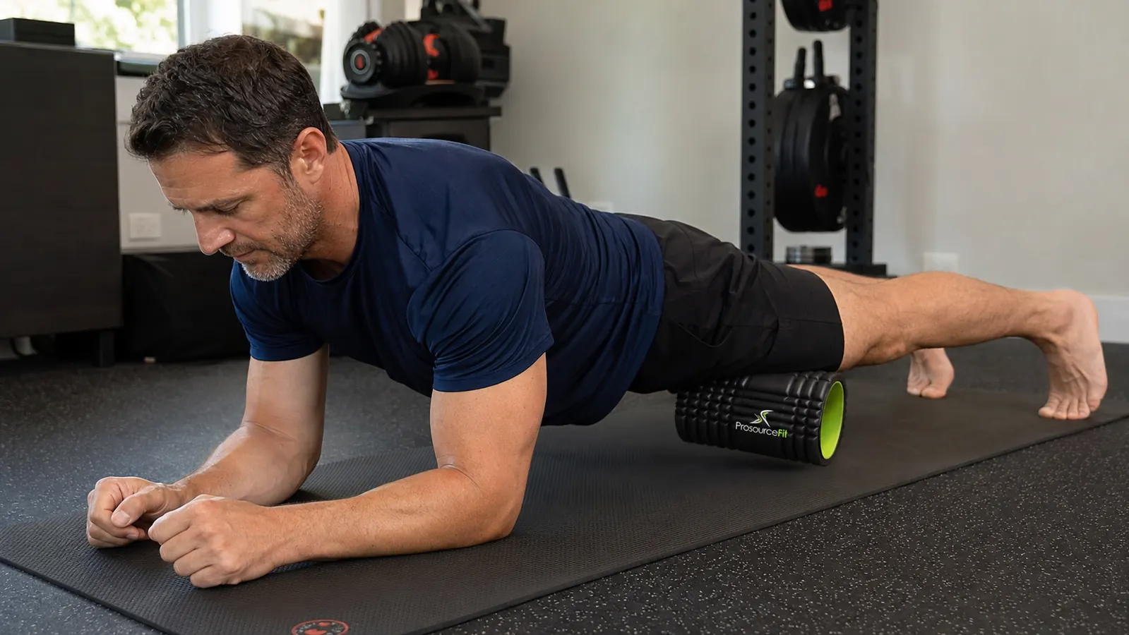 Athlete performing quad foam rolling in a forearm plank position on a foam roller