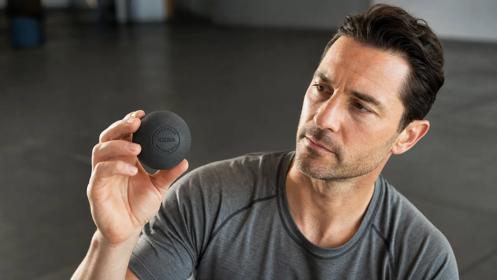 Hand pressing a Kieba massage ball against the base of a foot to work the plantar fascia