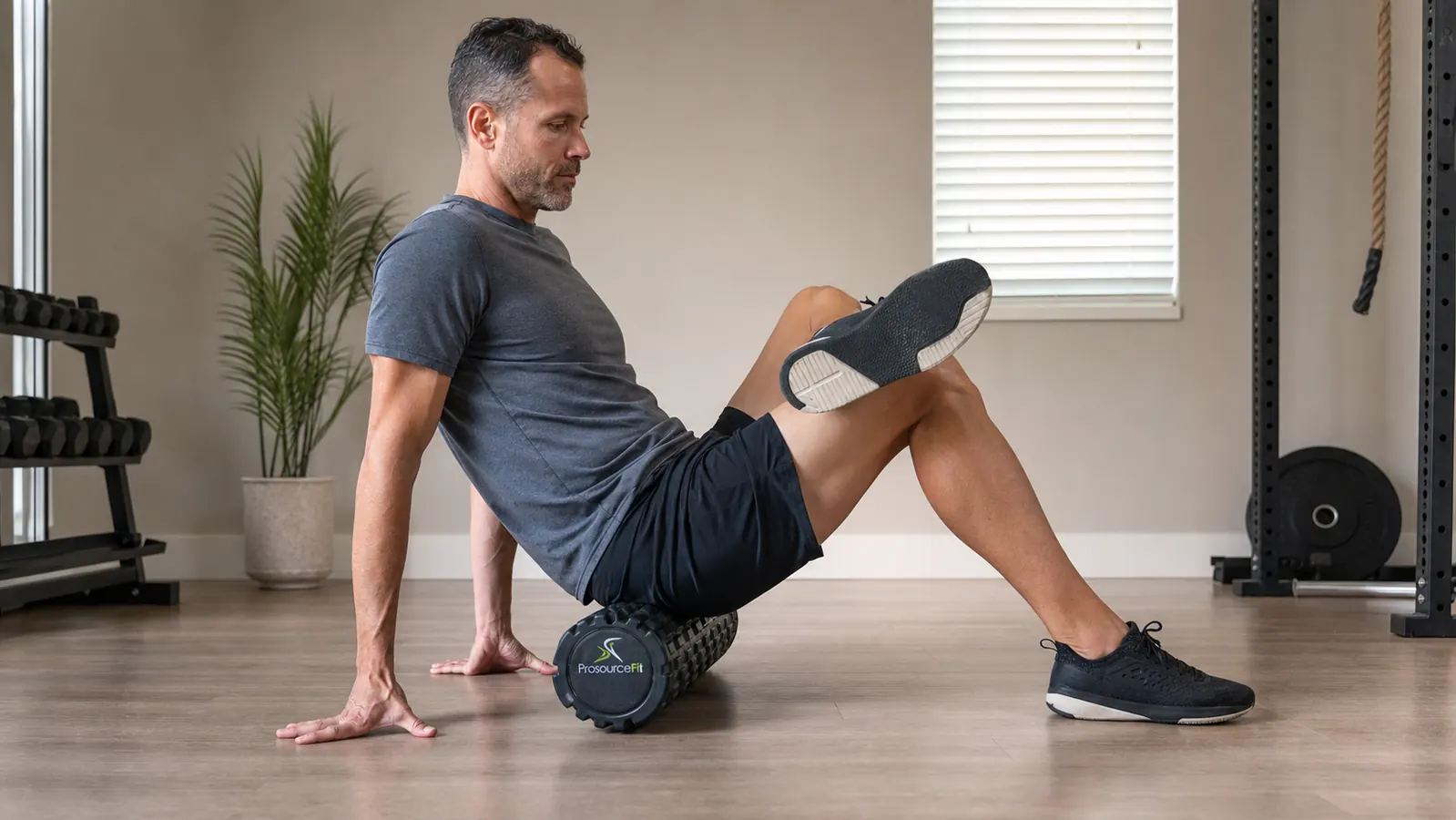 Man using a ProsourceFit foam roller on his upper back on a yoga mat